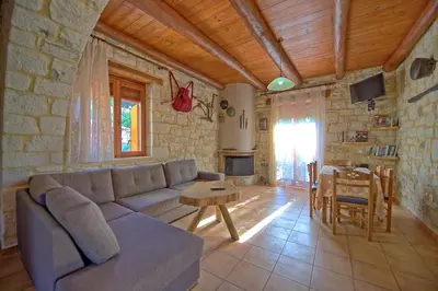 a living room with a couch and a table at Villa Vrisses by PosarelliVillas in Vryses