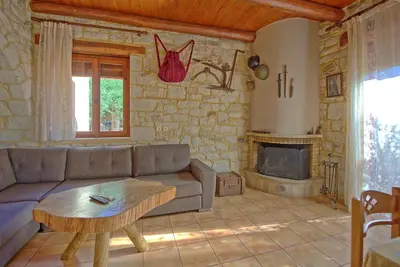 a living room with a couch and a fireplace at Villa Vrisses by PosarelliVillas in Vryses