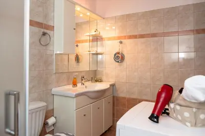 a bathroom with a sink and a toilet and a mirror at Aroma of the Sea in Kissamos