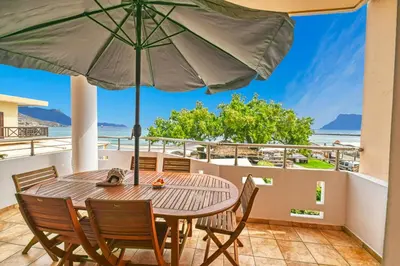 a table and chairs on a balcony with an umbrella at Armonia in Kissamos