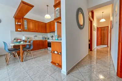 a kitchen with wooden cabinets and a table and chairs at Armonia in Kissamos