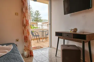 a room with a bed and a television and a table at Armonia in Kissamos