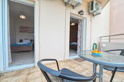 a patio with a table and chairs and a bedroom at Armonia in Kissamos