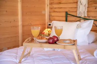 a tray of fruit and drinks on a bed at Wooden House Apts - Between Balos & Elafonissi in Kaláthenai