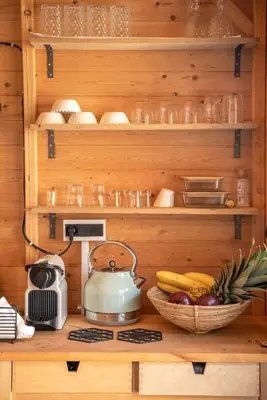 a kitchen with wooden shelves and a bowl of fruit at Wooden House Apts - Between Balos & Elafonissi in Kaláthenai