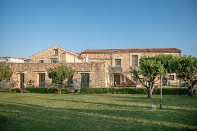 a large stone house with a lawn in front of it at Ondathaki Pirgos in Pírgos Psilonérou