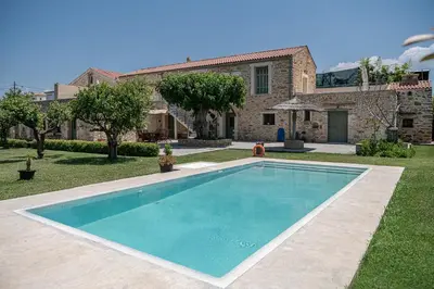 a swimming pool in front of a house at Ondathaki Pirgos in Pírgos Psilonérou