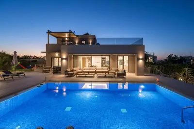 a villa with a swimming pool at night at Imperium Luxury Villas-Sauna, Jacuzzi, Heated Pool & Gym-Chania in Kato Galatas