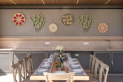 a long table with chairs and plates on a wall at Imperium Luxury Villas-Sauna, Jacuzzi, Heated Pool & Gym-Chania in Kato Galatas