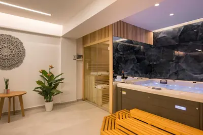 a bathroom with a tub and a table at Imperium Luxury Villas-Sauna, Jacuzzi, Heated Pool & Gym-Chania in Kato Galatas