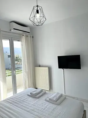 a bedroom with a bed with a flat screen tv at Nidus 101 in Souda