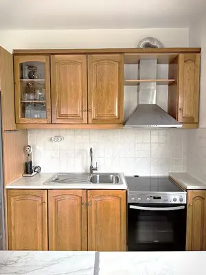 a kitchen with wooden cabinets and a sink and a stove at Nidus 101 in Souda