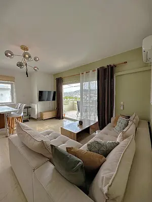 a living room with a large couch and a table at Nidus 101 in Souda