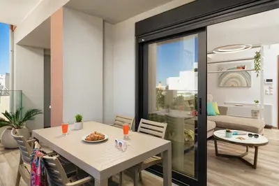 a dining room with a white table and chairs at Aquadia Beach Apartment in Chania Town
