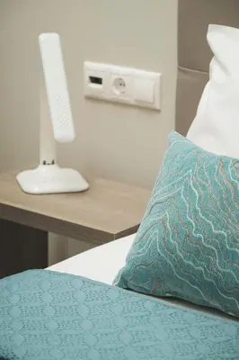 a bed with a pillow and a desk with a computer at Aquadia Beach Apartment in Chania Town