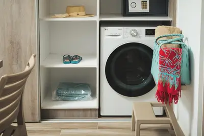 a washer and dryer in a kitchen with a table at Aquadia Beach Apartment in Chania Town