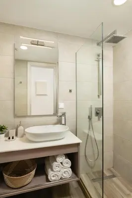a bathroom with a sink and a shower at Aquadia Beach Apartment in Chania Town