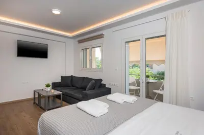 a white bedroom with a bed and a couch at Urban Residences Chania in Chania Town