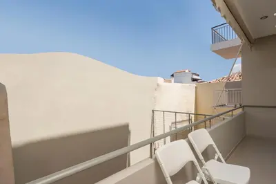 a balcony with two white chairs on a building at Urban Residences Chania in Chania Town