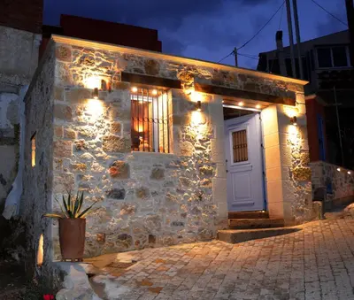 a stone house with lights on the side of it at Mouse House with Sea View and Mini Pool in Plataniás