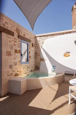 a room with a hot tub in a brick wall at Mouse House with Sea View and Mini Pool in Plataniás