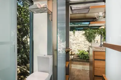 a bathroom with a toilet and a large window at Luxury TreeHouse - A breath away from the beach in Loutrákion