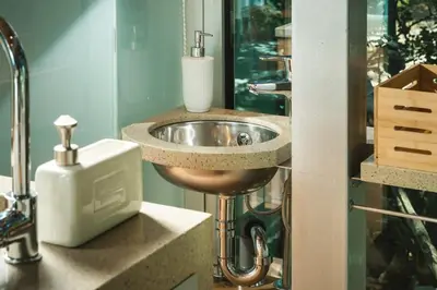 a bathroom with a sink and a soap dispenser at Luxury TreeHouse - A breath away from the beach in Loutrákion