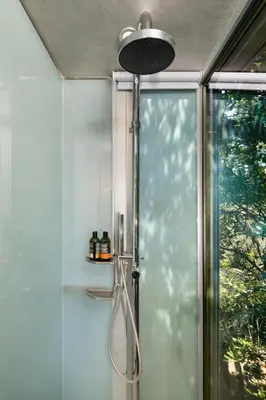 a shower with a glass door next to a window at Luxury TreeHouse - A breath away from the beach in Loutrákion