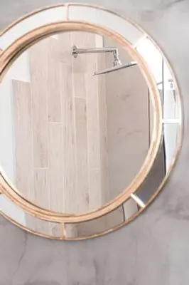 a round mirror hanging on a wall in a bathroom at Esperanto seafront studio in Agia Marina Nea Kydonias