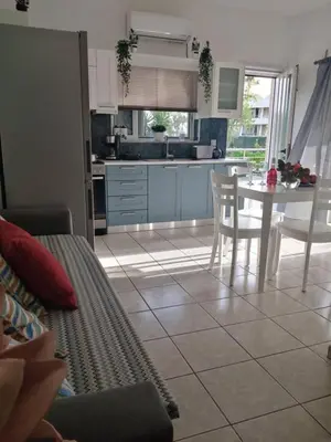 a kitchen and dining room with a table and chairs at Cozy Home (close to the beach) in Agia Marina Nea Kydonias