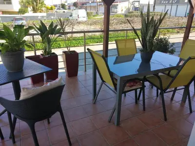 a table and chairs on a patio with plants at Cozy Home (close to the beach) in Agia Marina Nea Kydonias