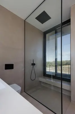 a glass shower in a bedroom with a window at Villa al Sur in Chania Town