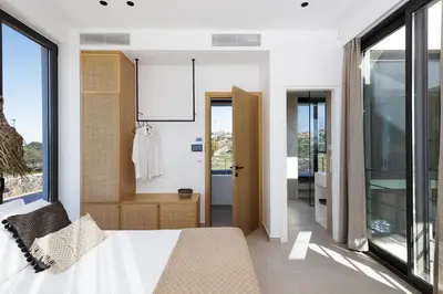 a bedroom with a bed and a large window at Villa al Sur in Chania Town