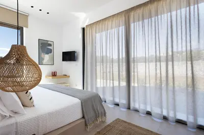 a bedroom with a bed and a large window at Villa al Sur in Chania Town