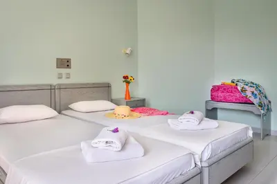 two beds in a room with towels on them at Louladakis Apartments in Kolymvari