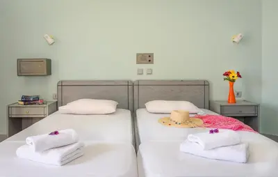two beds with towels and a hat on them at Louladakis Apartments in Kolymvari