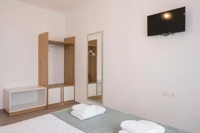 a bedroom with a bed with two white towels at INDIGO BLUE Seaside Deluxe Apartments in Kissamos