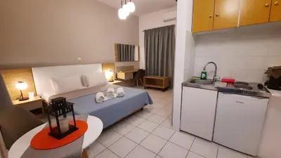 a bedroom with a bed and a kitchen in it at Stelios Studios Sougia in Sougia