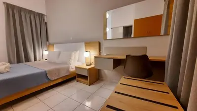 a bedroom with a bed and a desk and a chair at Stelios Studios Sougia in Sougia