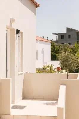 a white house with an open door at Grey House in Chorafakia