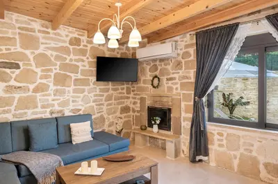 a living room with a blue couch and a stone wall at Villa Vanka in Chania Town
