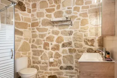 a stone bathroom with a toilet and a sink at Villa Vanka in Chania Town