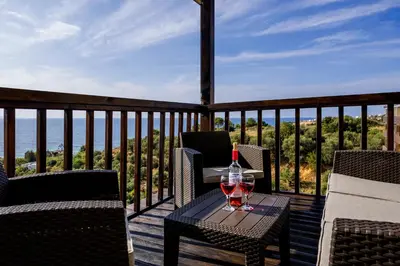 a glass of wine sitting on a table on a deck at Dreamy View Inn in Chania Town