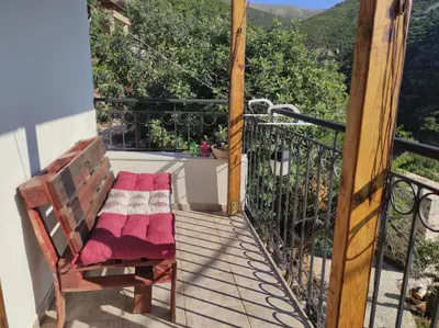 a wooden porch with a bench on a balcony at Stefanis traditional house - Kampos in Kámbos