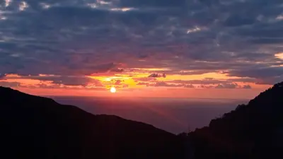 a sunset in the mountains with the sun in the sky at Stefanis traditional house - Kampos in Kámbos