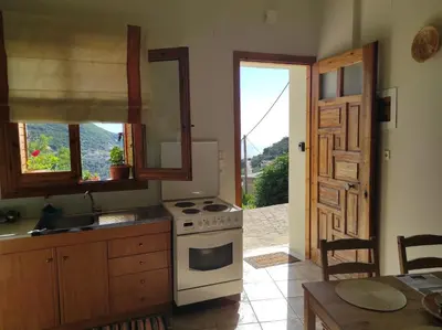 a kitchen with a stove and a sink and a window at Stefanis traditional house - Kampos in Kámbos