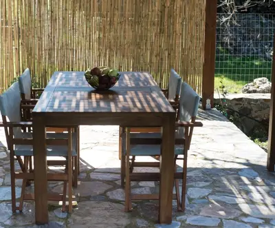 a wooden table with chairs and a bowl of fruit on it at jAne's house in Ravdhoúkha