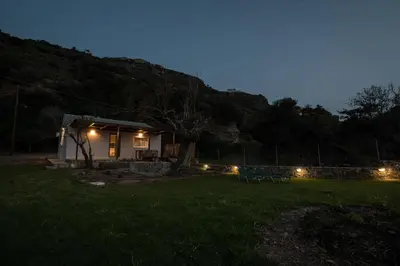 a small house with lights in a yard at night at jAne's house in Ravdhoúkha