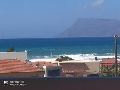 a view of the ocean and a beach with houses at Castel View Experience in Kissamos