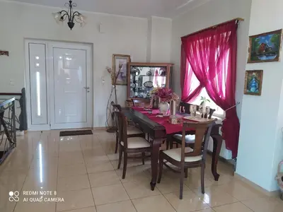 a dining room with a table and a pink curtain at Castel View Experience in Kissamos